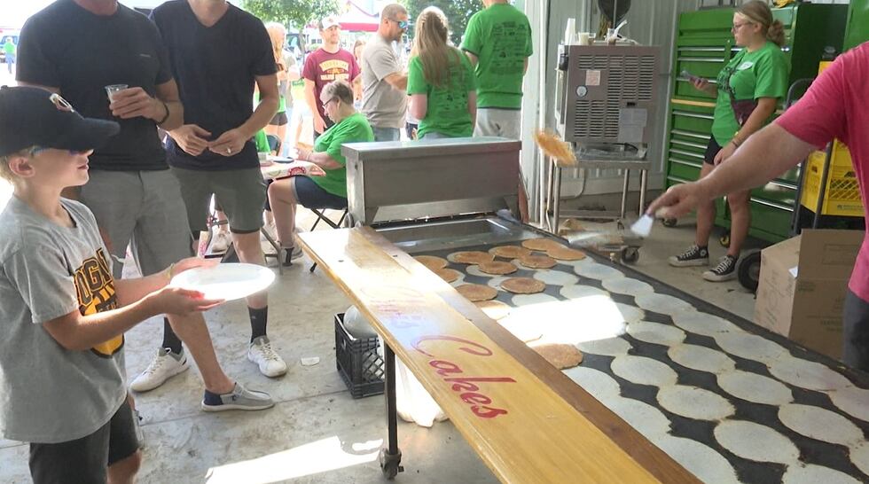 Pictured here, community attendees enjoy a free pancake breakfast while seeing farm equipment,...