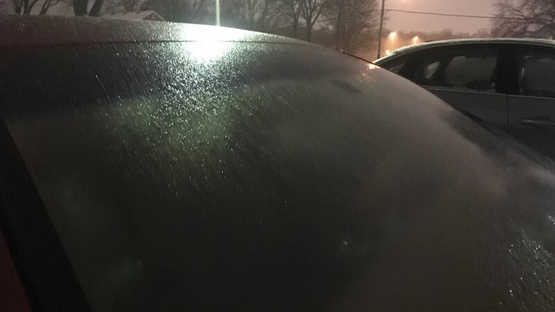 Freezing drizzle causing a glaze of ice on car windshield.