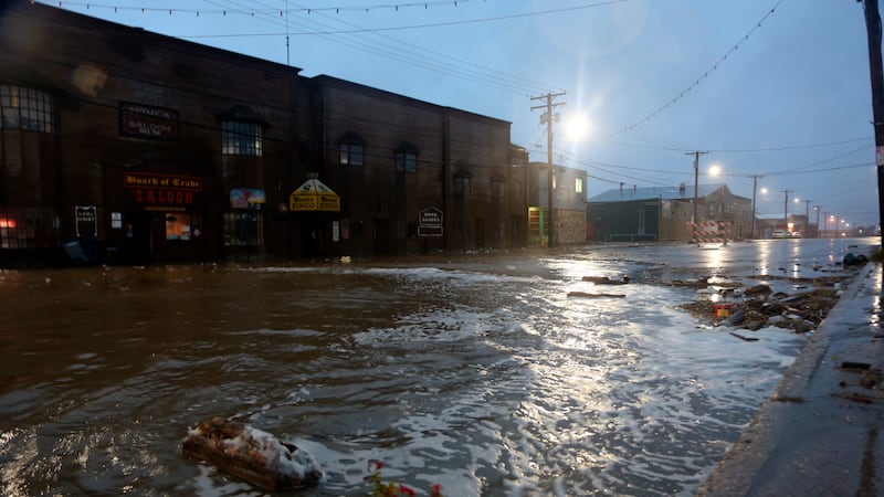 Water rushes down Front Street, just a half block from the Bering Sea, in Nome, Alaska, on...