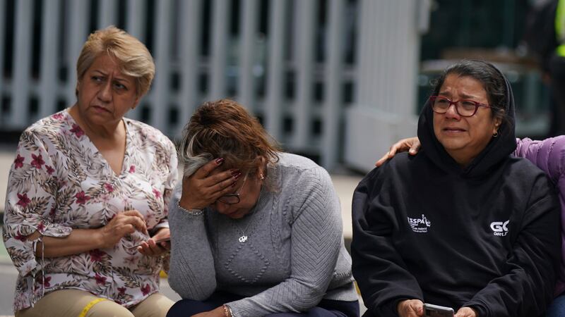 People gather outside after a magnitude 7.6 earthquake was felt in Mexico City, Monday, Sept....