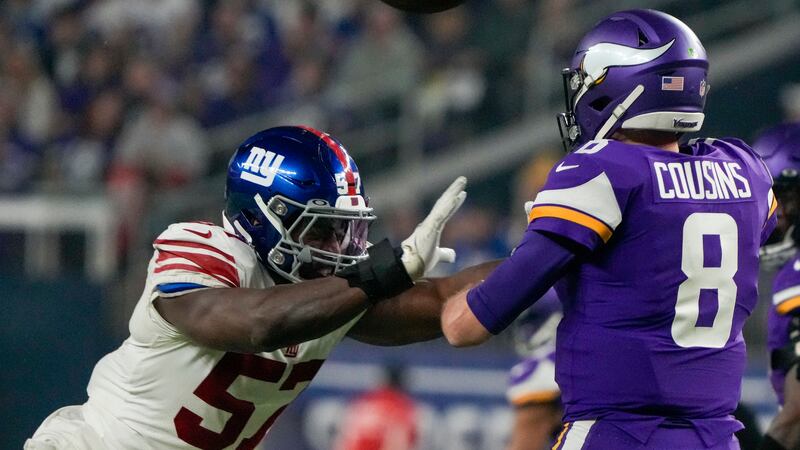 Minnesota Vikings' Kirk Cousins throws as he's pressured by New York Giants' Jarrad Davis...
